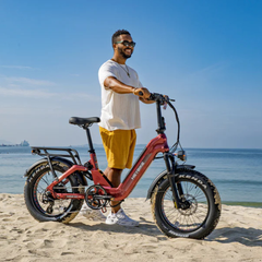 Man standing beside the red Heybike Ranger 3.0 Pro on a beach