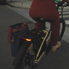 Rider on a Blix Sol X Comfort eBike with rear cargo bag and illuminated taillight