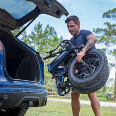 Man lifting a folded Heybike Mars 3.0 electric bike from a vehicle.