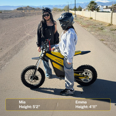 Two riders standing with a Classic yellow Heybike Villain on a dirt road.