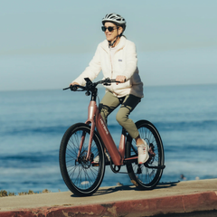 Rider using the pink Heybike Venus Electric Bike by the coast