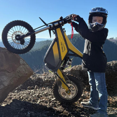 Young rider performing a wheelie on a Classic yellow Heybike Villain.