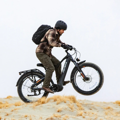 Rider using a black Heybike Alpha electric bike on a sandy trail.