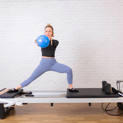 Align-Pilates A8-Pro Reformer 64cm Legs in use for standing Pilates exercise with exercise ball