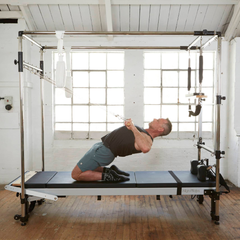 Align-Pilates Full Cadillac Frame (for A & C Series) in use for kneeling Pilates exercise with straps