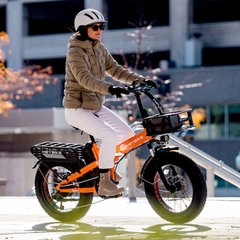 Woman riding an orange Heybike Mars 2.0 folding electric bike through a wet urban area.