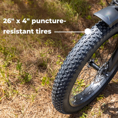 Close-up of the Jasion Thunder's front fat tire, with text overlay reading 26 x 4 inch puncture-resistant tires
