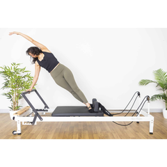 Align-Pilates R8-Pro Light Commercial Reformer White in use for side stretch Pilates reformer exercise