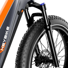 Close-up of the Heybike Hero front suspension fork, tire, and frame.