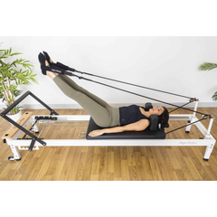 Align-Pilates R8-Pro Light Commercial Reformer White in use with leg straps for Pilates reformer exercise
