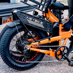 Close-up of the orange Mars 2.0 folding frame, battery, rear wheel, and drivetrain.