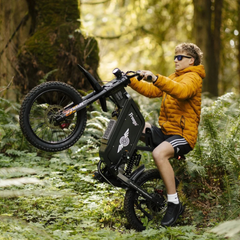 FreeGo X1 Electric Dirt Bike rider wheelie forest view