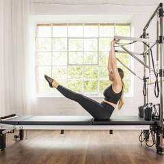 Align-Pilates C8 Pro Reformer in use with half trapeze and straps for Pilates exercise