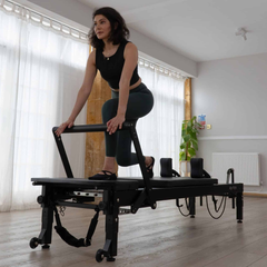 Align-Pilates C8-Pro Noir Reformer Black in use for standing Pilates reformer exercise