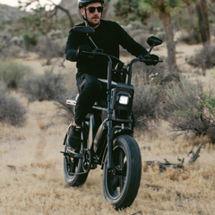 Rider using the black Heybike Saturn electric bike on a desert trail.