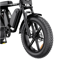 Close-up of the Saturn front suspension fork, headlight, and fat tire.